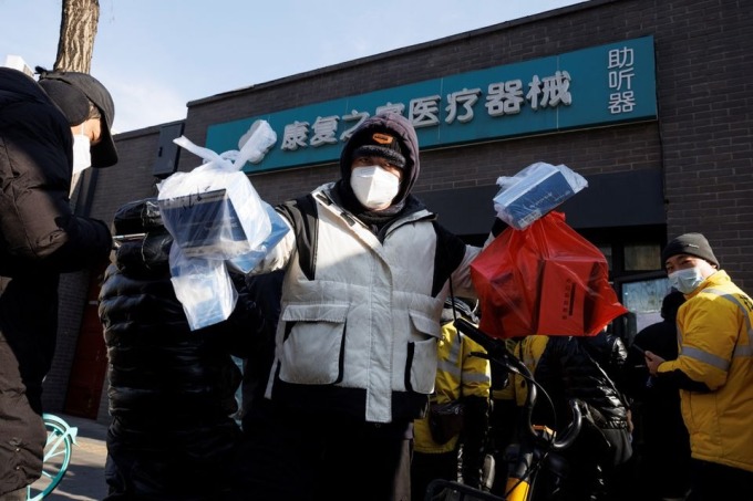 Một người giao hàng lấy thuốc từ hiệu thuốc ở Bắc Kinh ngày 7/12. Ảnh: Reuters