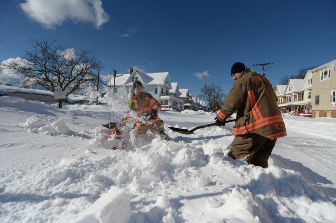 Lính cứu hỏa dọn tuyết ngập tới đầu gối ở Buffalo ngày 20/12. Ảnh: AFP