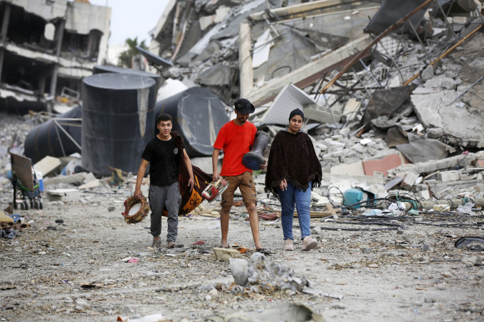 Người dân Palestine cầm theo những gì còn nguyên vẹn sau các đợt oanh tạc của Israel ở Gaza City, Gaza ngày 25/11. Ảnh: AFP