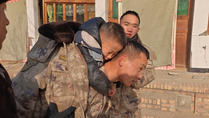 Binh sĩ Trung Quốc giải cứu học sinh kẹt trong trường sau động đất tại Cam Túc, ngày 19/12. Ảnh: AFP