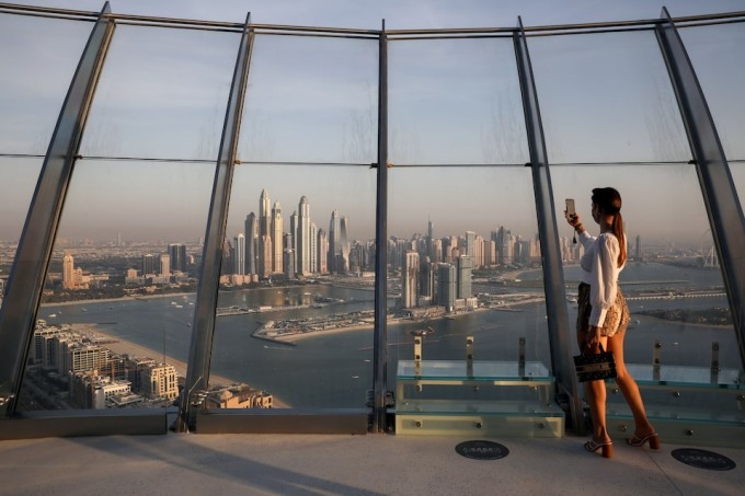 Một phụ nữ chụp ảnh từ tháp Palm Tower tại Dubai (UAE). Ảnh: Reuters