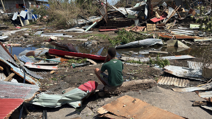 Một thiếu niên gần đống đổ nát sau bão Chido tại Labattoir, Mayotte thuộc Pháp, ngày 15/12. Ảnh: Reuters