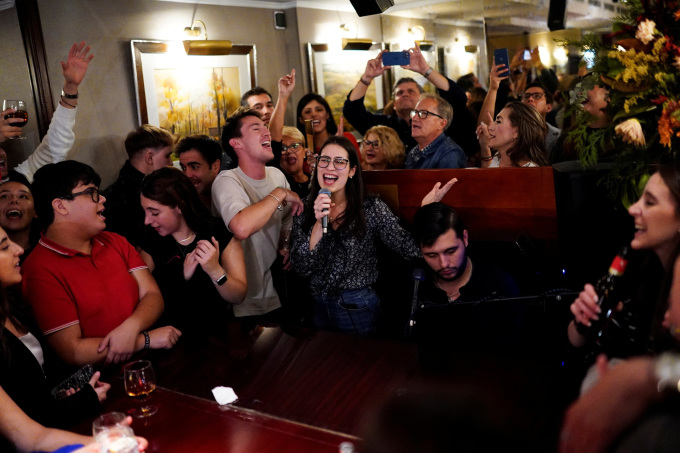 Mọi người hát theo người chơi đàn piano tại quán bar Tony 2 ở Madrid, Tây Ban Nha ngày 29/9. Ảnh: Reuters