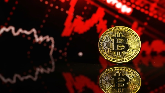 Biểu trưng Bitcoin đặt trước một biểu đồ minh họa xuống giá. Ảnh: CNBC