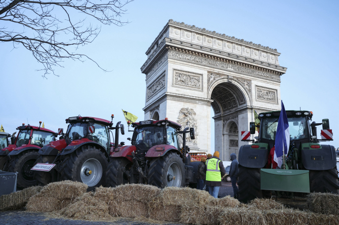 Máy kéo và cỏ khô của nông dân vây Khải Hoàn Môn trên đại lộ Champs-Elysees, Paris ngày 1/3. Ảnh: AFP