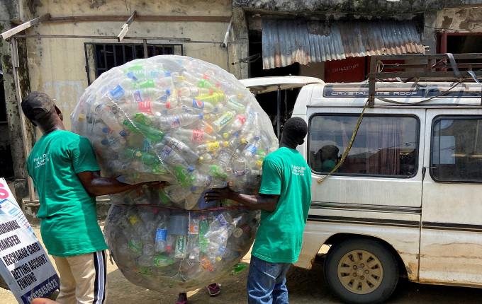 Công nhân chất bao chai nhựa lên xe sau khi gom từ bãi rác ở Port Harcourt, Nigeria ngày 31/10/2022. Ảnh: Reuters