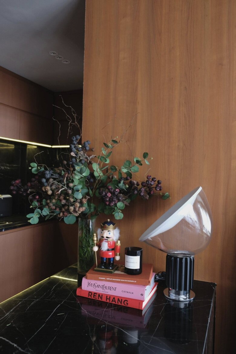 Trên bàn đảo đá, Hoàng Ku chỉ thêm một cụm trang trí nhỏ gồm đèn, vài cuốn sách, nến thơm, bình lá và một tượng lính chì, vừa đủ để tạo tinh thần mùa lễ mà không làm mất vẻ tối giản vốn có.