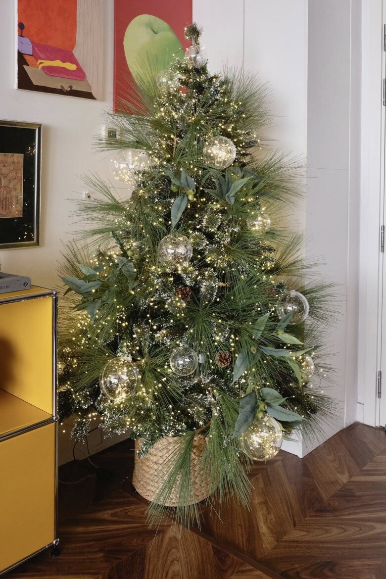 Ở góc nhà đặt một cây thông nhỏ được anh mua từ 10 năm trước. Cây thông này được trang trí bằng đèn vàng li ti và những quả châu trong suốt, tạo cảm giác nhẹ nhàng mà vẫn tinh tế.