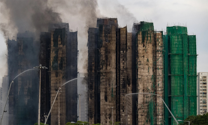 Xe cứu hỏa phun nước vào các tòa nhà tại cụm chung cư Wang Fuk Court, Hong Kong ngày 27/11. Ảnh: AP