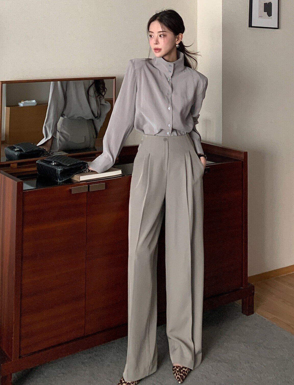 Quần âu phối áo sơ mi là công thức kinh điển nhưng chưa bao giờ lỗi thời. Dáng quần đứng, cạp cao giúp vóc dáng gọn gàng, tôn vòng eo. Khi chọn phom suông nhẹ, tổng thể sẽ bớt cứng nhắc và trẻ trung hơn.