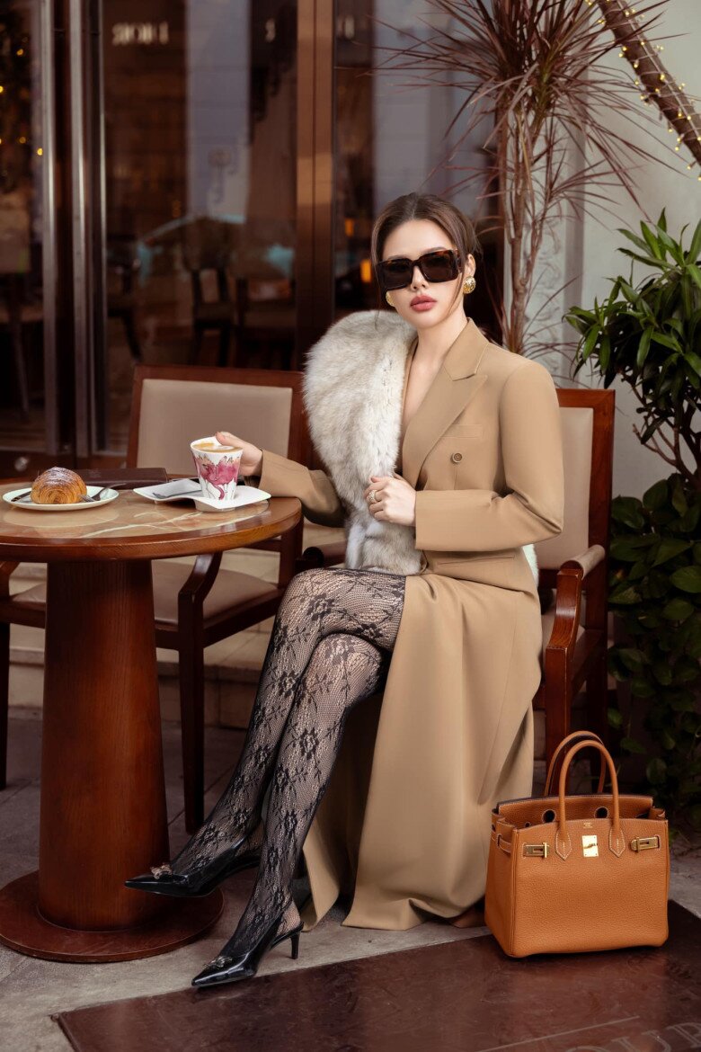 Một cách để biến chiếc áo khoác màu be dáng dài trở nên sang trọng hơn đó là kết hợp cùng chi tiết lông mềm mại giống như dâu hào môn Phanh Lee diện. Sự phối hợp với tất ren đen và giày mũi nhọn giúp tổng thể thêm phần thời thượng, cân bằng giữa nét thanh lịch và quyến rũ.