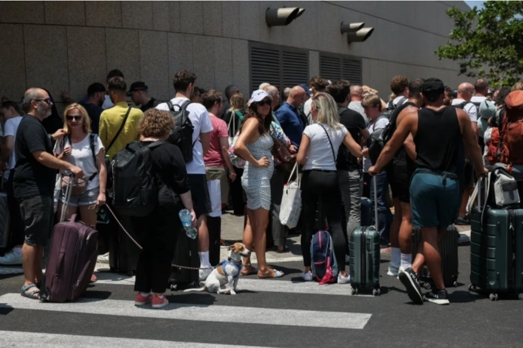 Người nước ngoài tập trung trước khi rời Israel bằng xe buýt sang Ai Cập ngày 17/6. Ảnh: Reuters