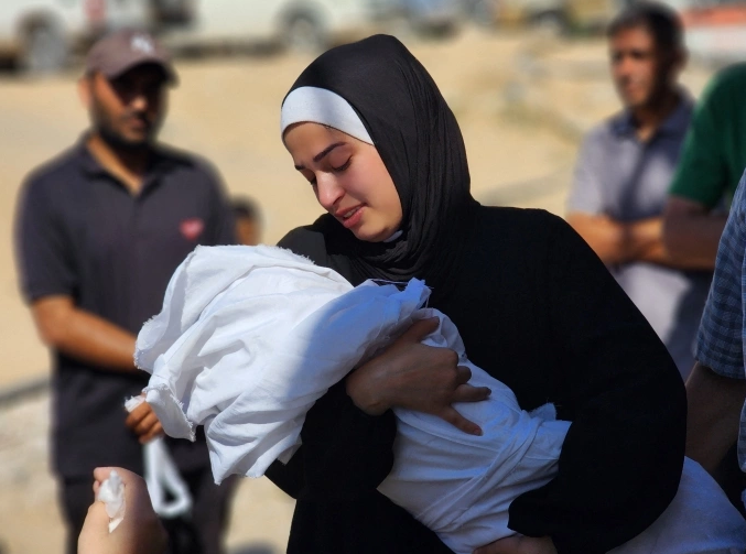 Người phụ nữ Palestine ôm thi thể người nhà thiệt mạng trong một vụ tấn công của Israel trong tang lễ ở bệnh viện Nasser, thành phố Khan Younis, ngày 26/6. Ảnh: AFP