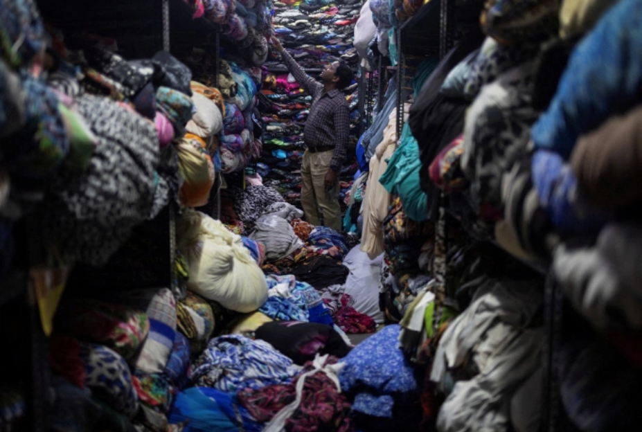 Công nhân tìm vải may quần áo tại một xưởng sản xuất hàng may mặc ở Noida, Ấn Độ, hôm 7/8. Ảnh: Reuters
