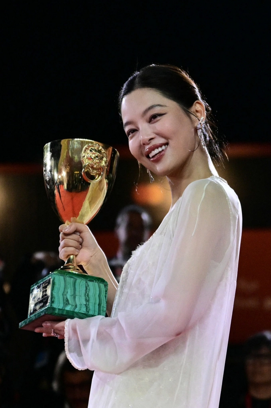 Tân Chỉ Lôi tạo dáng trên thảm đỏ với chiếc cúp Volpi cho Nữ chính xuất sắc Liên hoan phim Venice 2025. Ảnh: AFP