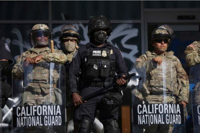 Cảnh sát và lính Vệ binh Quốc gia canh gác tại lối vào tòa nhà liên bang ở Los Angeles, bang California ngày 10/6. Ảnh: AP