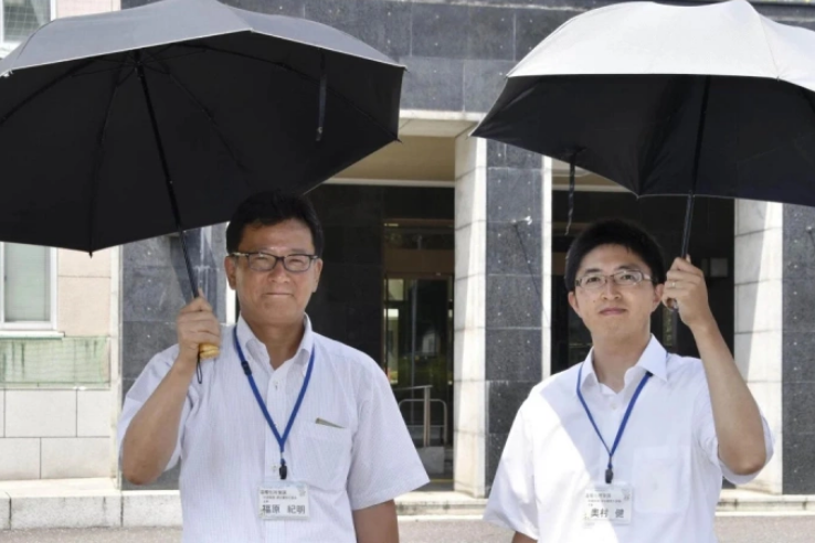 Hai quan chức Saitama dùng ô che nắng ở Nhật Bản. Ảnh: Kyodo