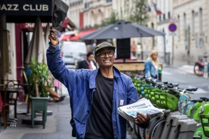 Ông Ali Akbar rao báo trên đường phố Paris, ngày 16/9. Ảnh: AFP