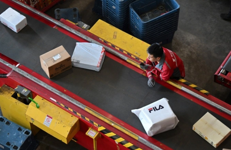 Công nhân trên dây chuyền phân loại các gói hàng tại kho của JD ở Bắc Kinh ngày 11/11. Ảnh: AFP