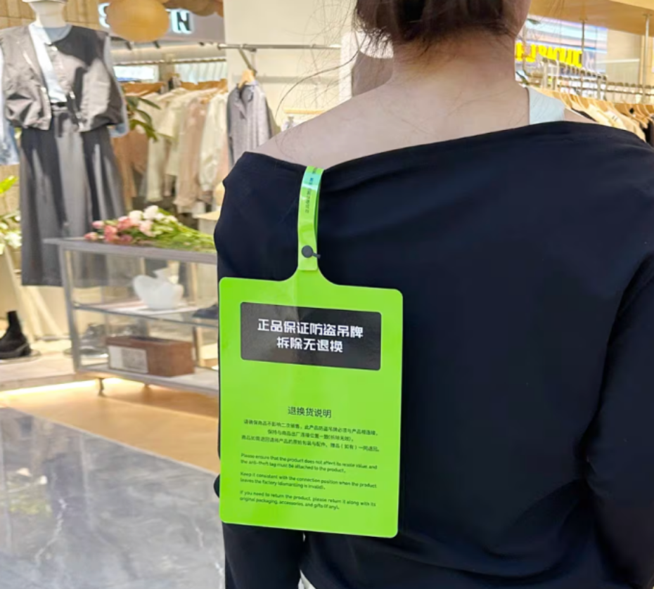 Một chiếc mác áo cỡ A4, làm từ chất liệu cứng, màu sắc nổi bật, gây khó chịu khi mặc. Ảnh: CNA