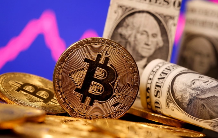 Biểu trưng của Bitcoin đặt cạnh các tờ đôla Mỹ. Ảnh: Reuters
