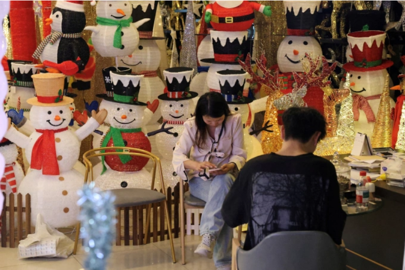 Nhân viên một gian hàng đồ trang trí Giáng sinh tại Nghĩa Ô (Trung Quốc). Ảnh: Reuters