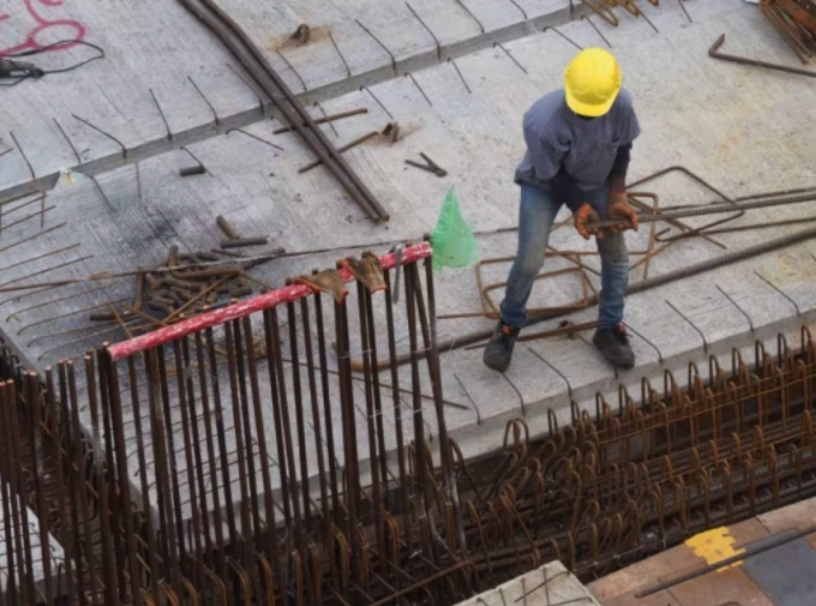 Một lao động nhập cư đang làm việc ở công trường Singapore. Ảnh: CNA