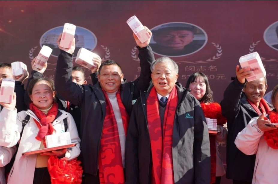 Ông Lăng Kế Hà (thứ ba từ trái sang), chụp ảnh kỷ niệm cùng các nông dân nhận thưởng Tết hôm 9/1 tại công ty Nông nghiệp Xanh ở tỉnh Giang Tây. Ảnh: China News