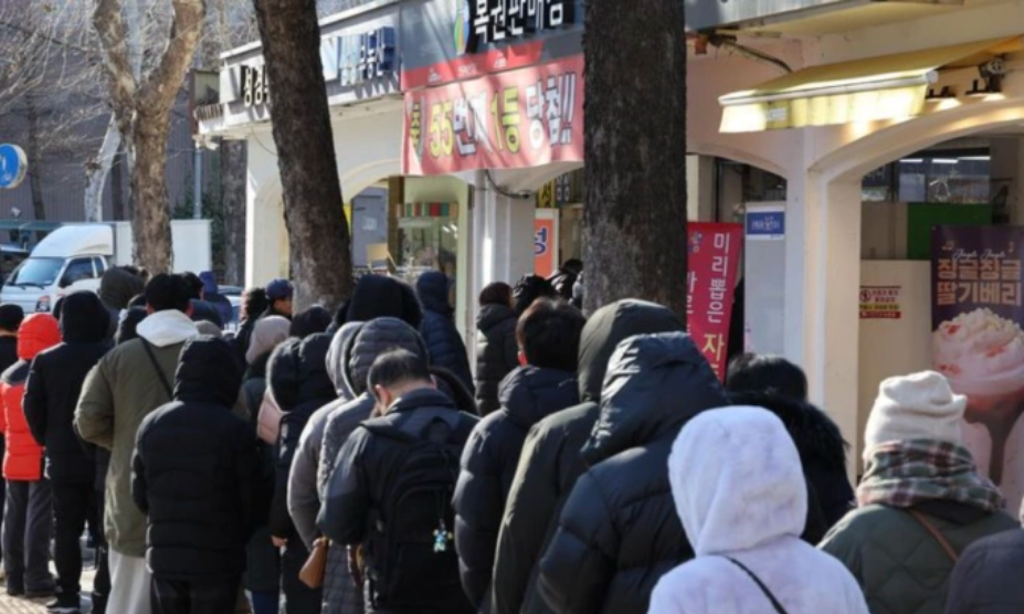 Dòng người xếp hàng chờ mua vé số tại một cửa hàng nổi tiếng thường xuyên trúng giải độc đắc ở Seoul, đầu năm 2026. Ảnh: Yonhap