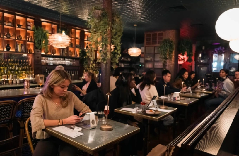 Quán bar được thiết kế cho các bàn đơn, có giá đỡ iPhone để khách giao tiếp cùng AI. Ảnh: NY Post