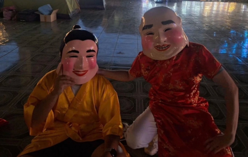 Đội trưởng cảnh sát Lertvarit Lertvorapreecha (phải) và đồng nghiệp cải trang thành người biểu diễn múa lân tại một hội chợ chùa, cuối tháng 2. Ảnh: Metropolitan police bureau, Royal Thai police