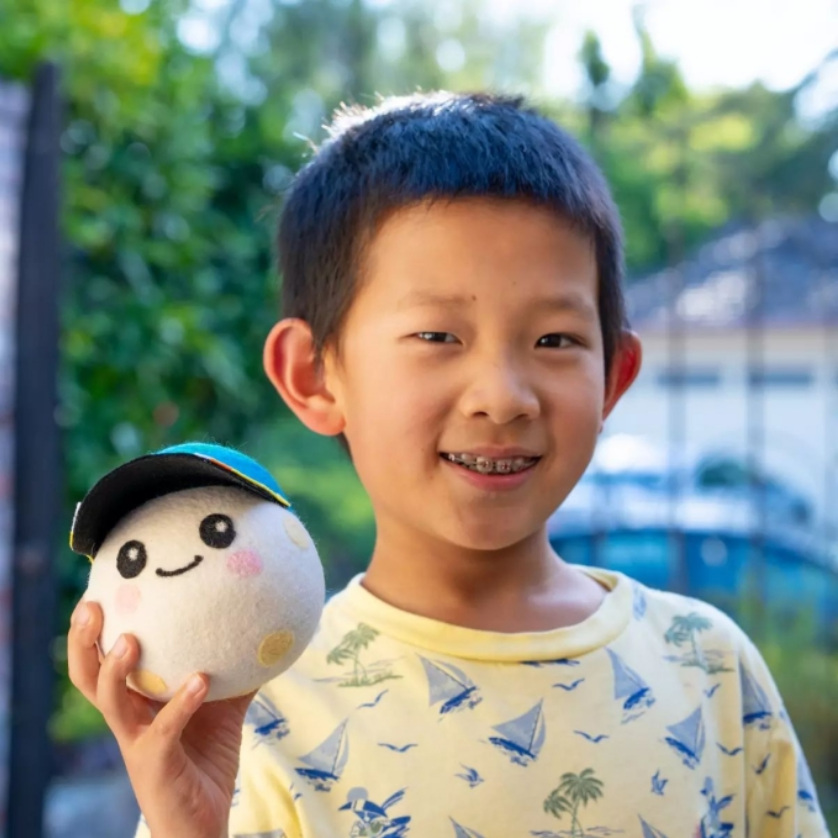 Lucas Ye cầm chú gấu bông Rise trong buổi lễ ra mắt linh vật hồi tháng 3/2026. Ảnh: Freelancer/NASA